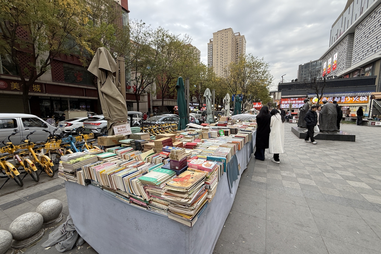 西安兴善寺西路旧书摊：旧书摊连绵几百米，顾客埋头在旧书堆里淘宝