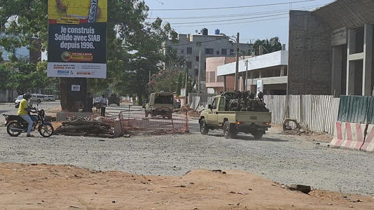 Soldiers ride in a military vehicle along a street amid an attempted coup in Cotonou Benin, Sunday Dec. 6, 2025.