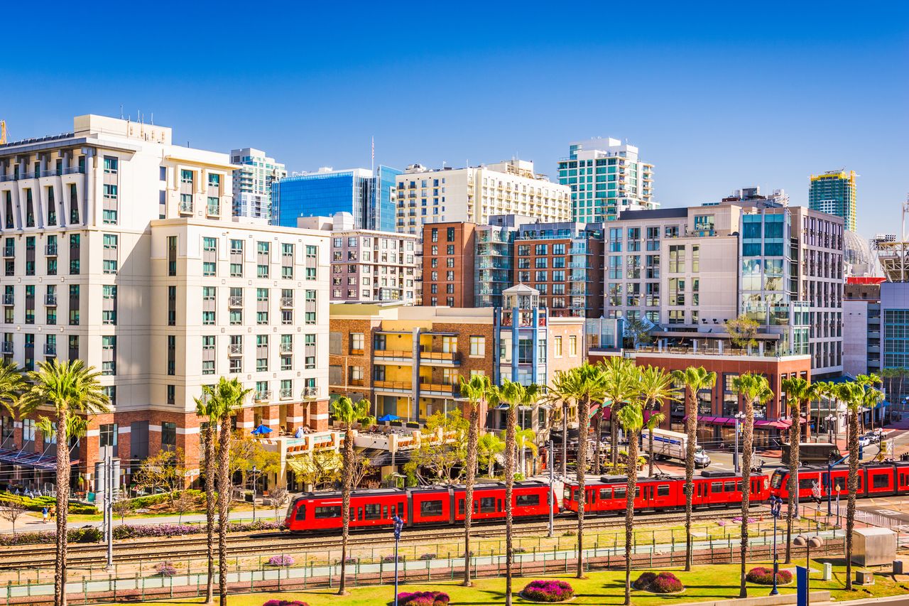 San Diego downtown with buildings and a red trolley passing by