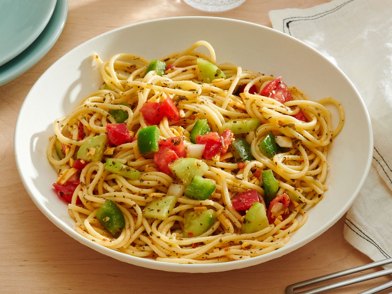 Spaghetti Salad in a bowl next to plates