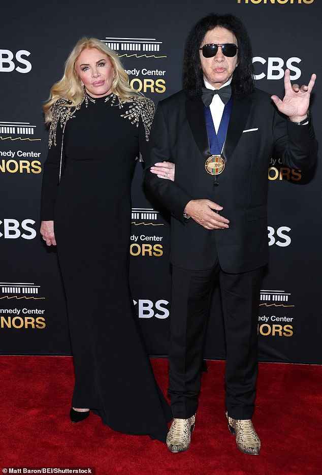 Simmons made a hand gesture for photogs as he posed with spouse&nbsp;Shannon Tweed, who wore a black gown to the event&nbsp;