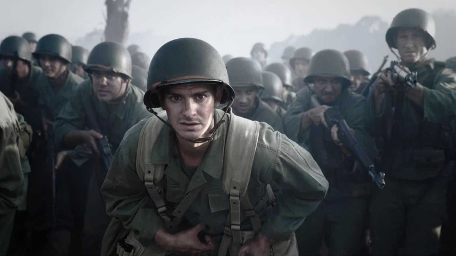 Andrew Garfield as Desmond Doss in front of a group of soldiers in Hacksaw Ridge