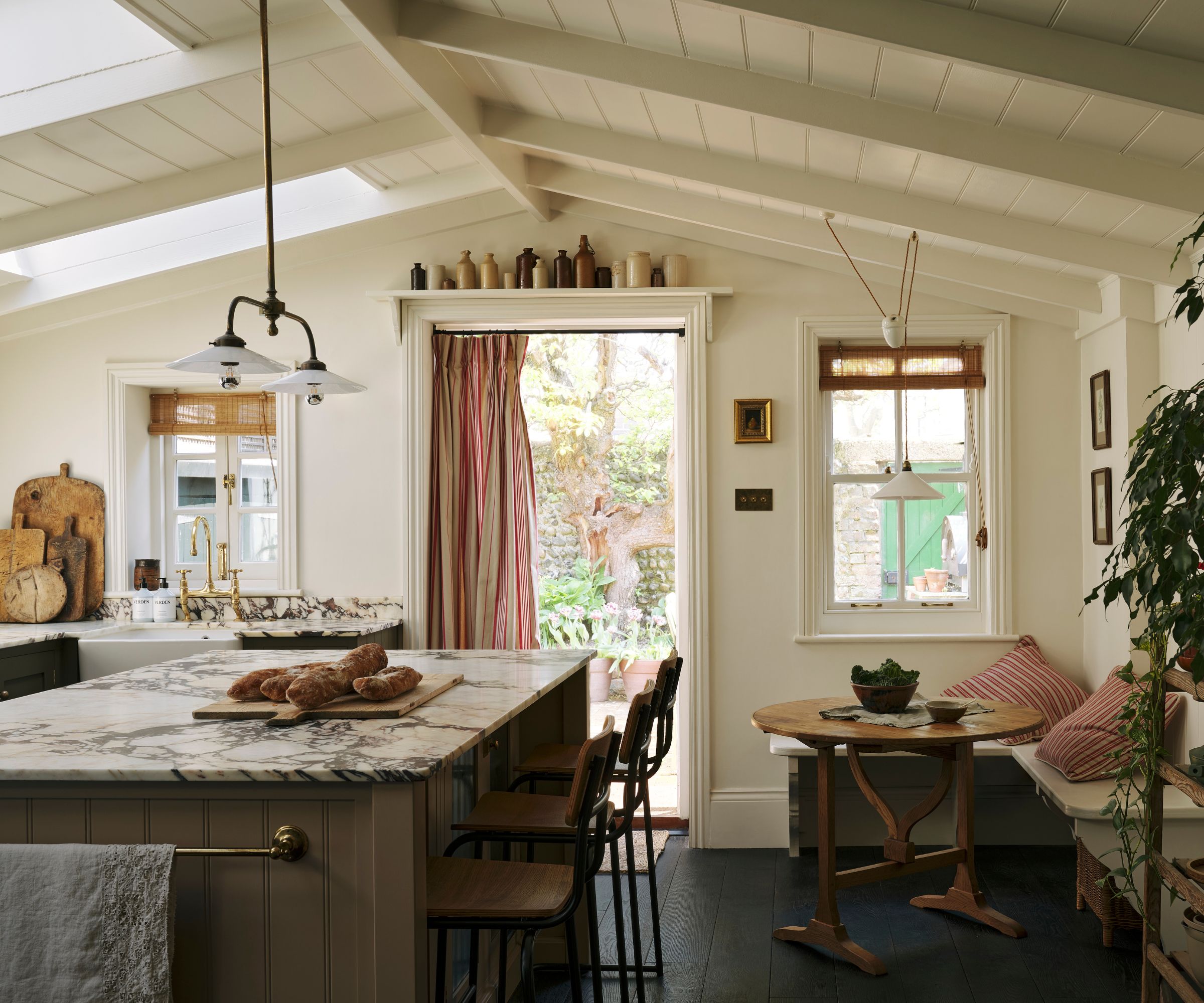 A large olive green kitchen with marble countertops and a cozy eat-in area