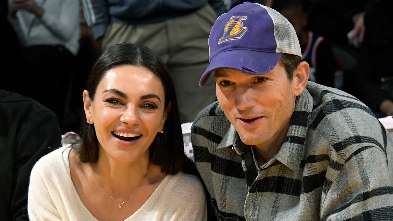Mila Kunis and Ashton Kutcher at a basketball game