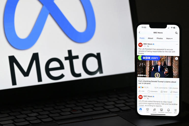 An illustration photograph taken on February 20, 2025 shows a Facebook post by BBC News about US President Donald Trump pictured on a phone screen next to the Meta Logo displayed on a laptop screen.