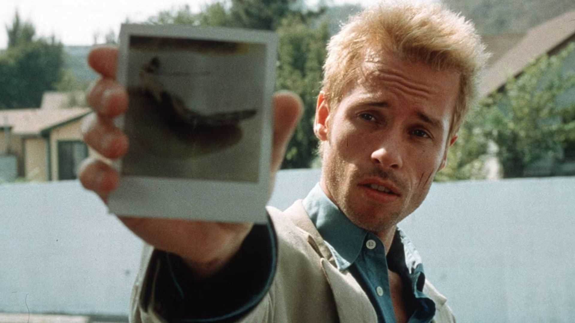 Guy Pierce as Leonard holding a Polaroid in Memento