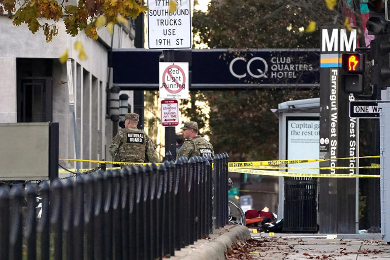 Nathan Howard/Reuters - PHOTO: National Guard members stand in a cordoned-off area with evidence markers placed on the ground, after two National Guard members were shot near the White House in Washington, D.C., Nov. 26, 2025.