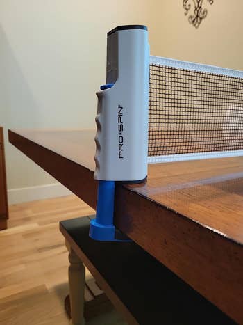 PRO-SPIN retractable table tennis net attached to a wooden table