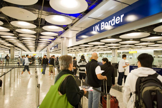 people queuing to cross the UK border at london s terminal five heathrow passport control