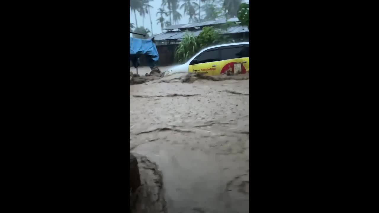 Cars swept away as floods surge through homes in Indonesia