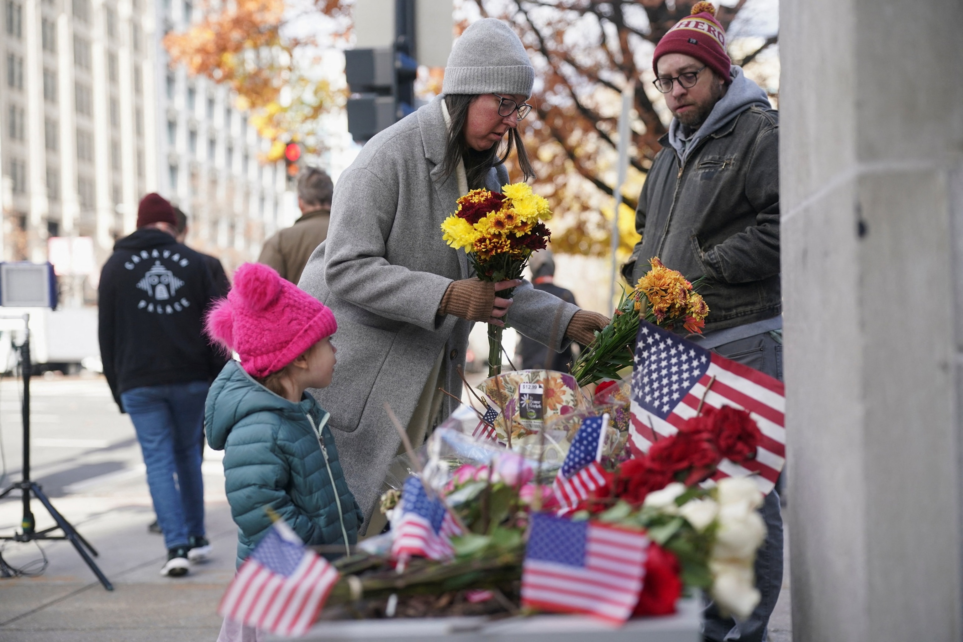 Nathan Howard/Reuters - PHOTO: People place flowers in a makeshift memorial set up after two National Guard members were shot, near the White House, in Washington, D.C., Nov. 28, 2025.