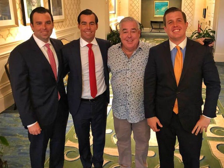 Morgan with his three sons in suits and ties in a hotel setting.