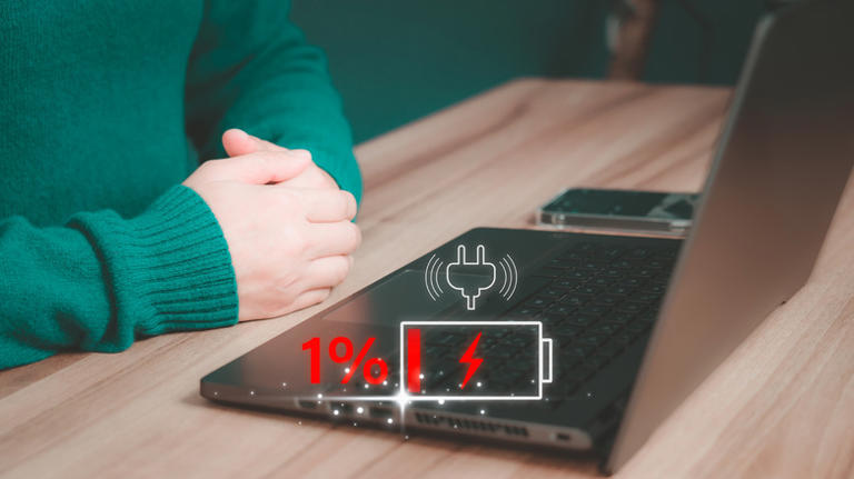 Person looking at a laptop running out of battery