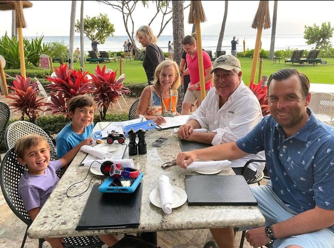 John Morgan with wife, son, and grandchildren in tropical setting.