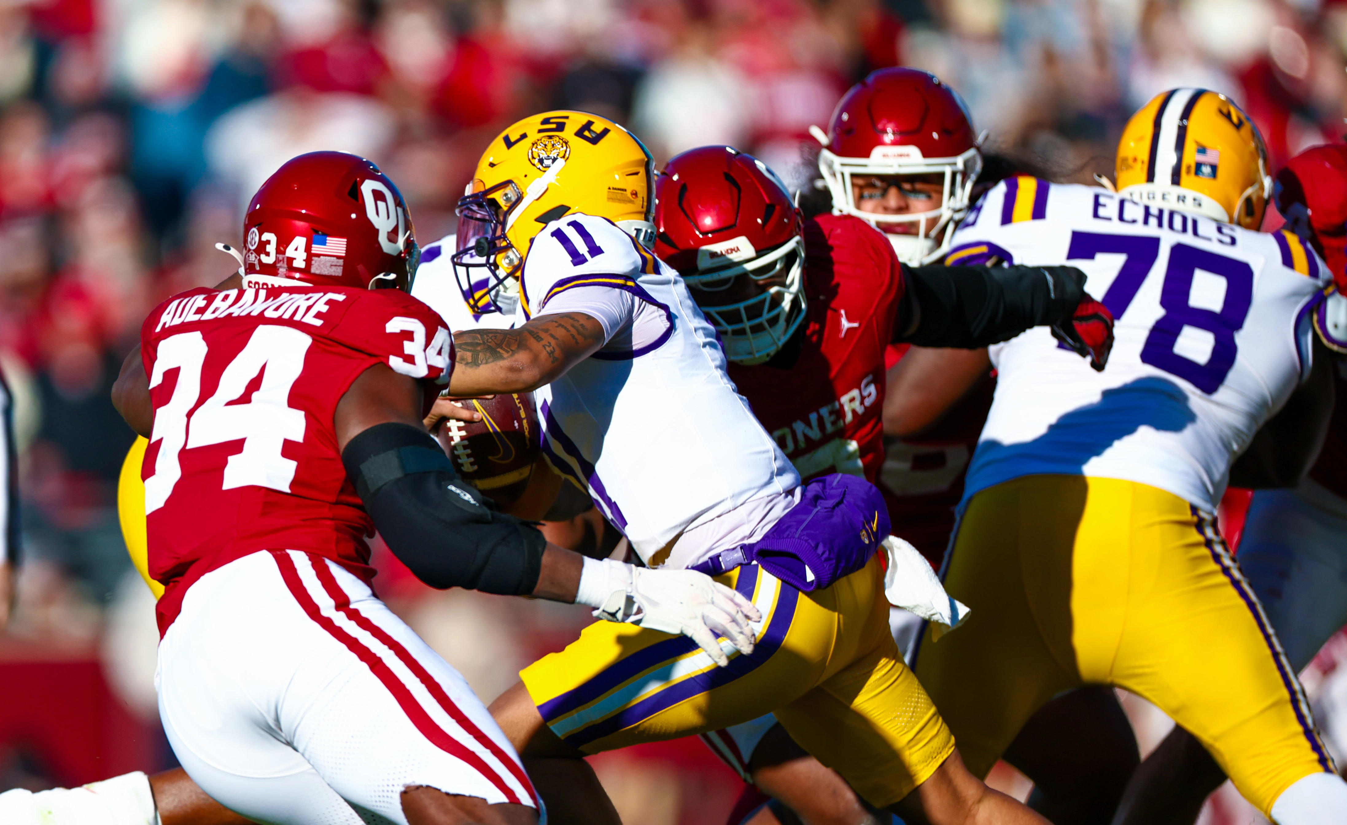 Nov 29, 2025; Norman, Oklahoma, USA; Louisiana State Tigers quarterback Michael van Buren Jr. (11) is pursued by Oklahoma Sooners defensive lineman Adepoju Adebawore (34) during the first half at Gaylord Family-Oklahoma Memorial Stadium. Mandatory Credit: Kevin Jairaj-Imagn Images