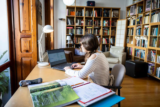 Una adolescente estudia en su casa con ayuda de la inteligencia artificial. 