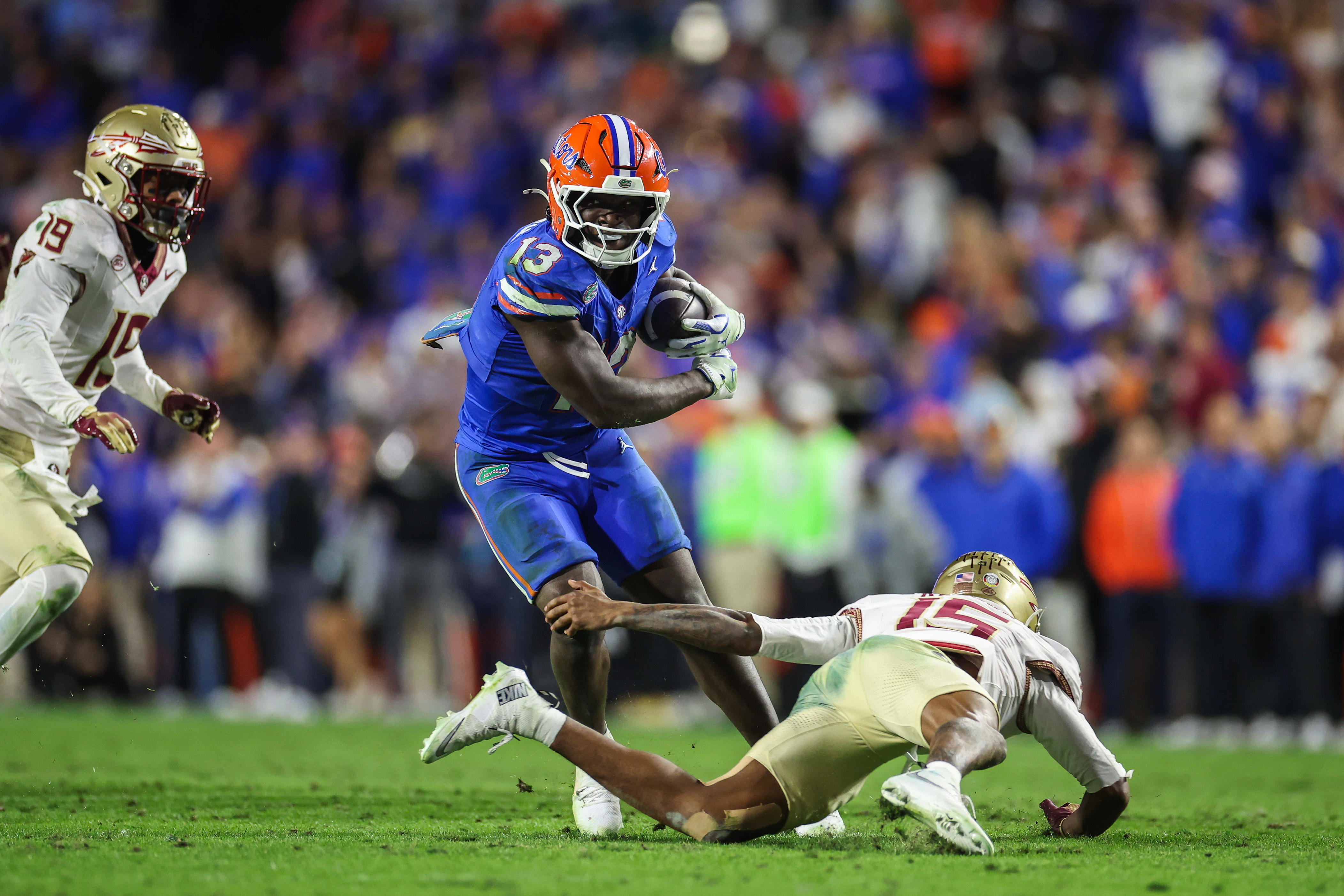 GAINESVILLE, FLORIDA - NOVEMBER 29: Jadan Baugh #13 of the Florida Gators runs with the ball against Shamar Arnoux #15 of the Florida State Seminoles during the second half of a game at Ben Hill Griffin Stadium on November 29, 2025 in Gainesville, Florida. (Photo by James Gilbert/Getty Images)