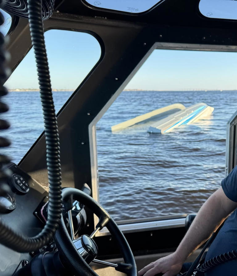 Lee County Marine Emergency Response Team - PHOTO: An overturned catamaran is seen, November 29, 2025, through the window of a rescue boat after an accident that killed three of the vessel's passengers and left one in critical condition, officials said.