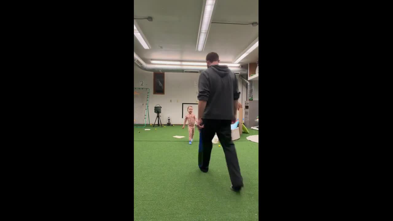 Father and son playing indoor baseball in Illinois, USA