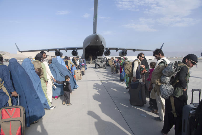 U.S. Air Force loadmasters and pilots assigned to the 816th Expeditionary Airlift Squadron load people being evacuated from Afghanistan onto a U.S. Air Force C-17 Globemaster III at Hamid Karzai International Airport in Kabul on Aug. 24, 2021. (Master Sgt. Donald R. Allen/U.S. Air Force/AP)