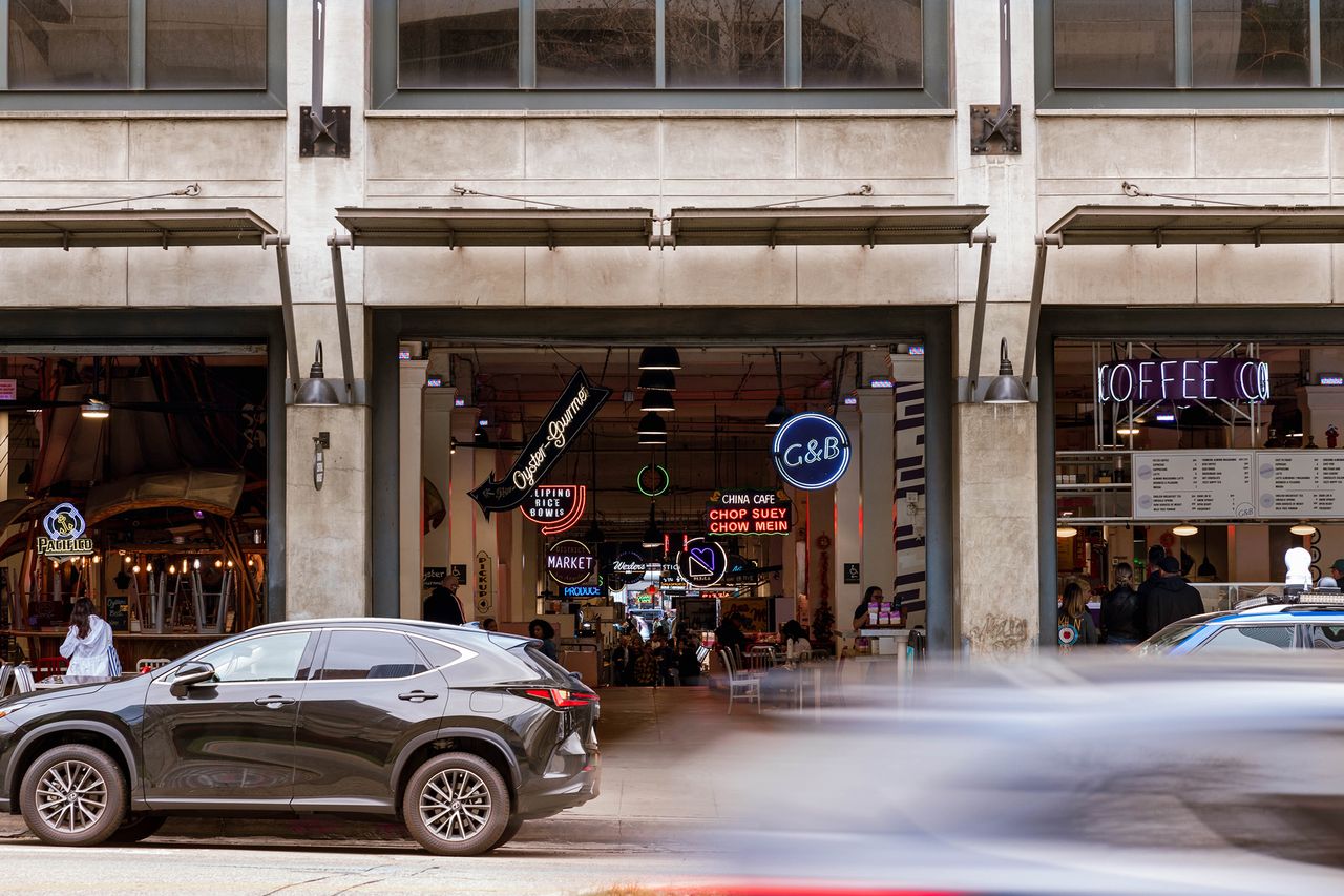Street view of a downtown area with storefronts and parked cars