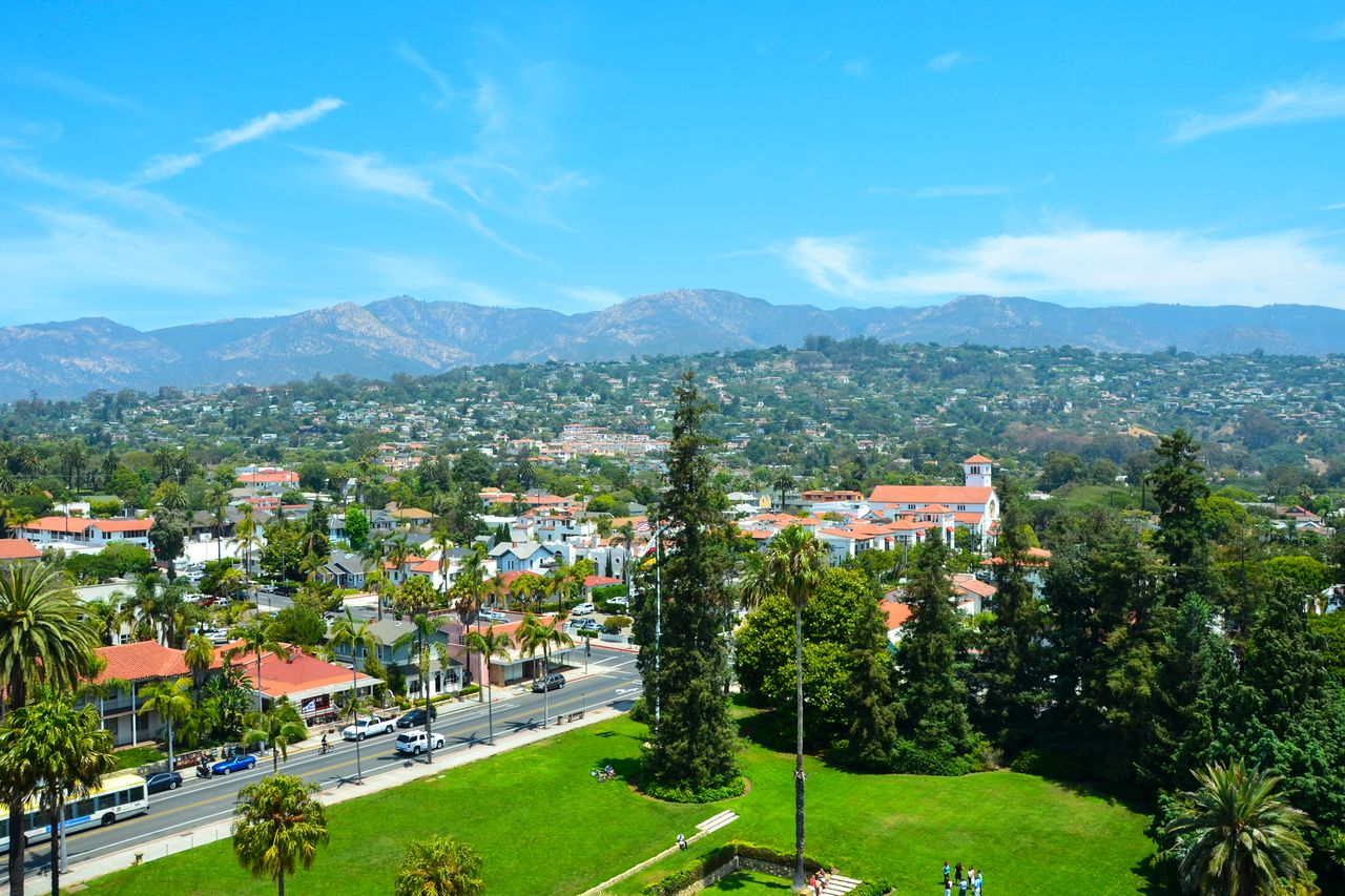 A view of Santa Barbara with buildings trees and mountains in the background