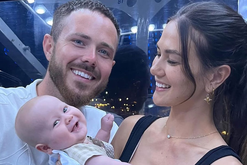 Gael Cameron and Nathan Gallagher smiling with, baby, Kayden Gallagher.