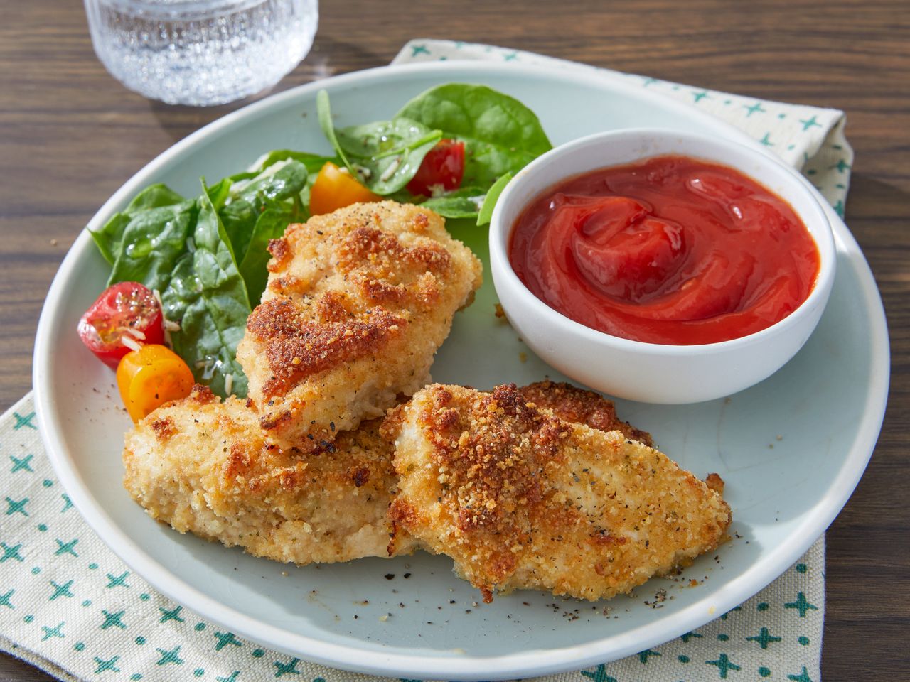 Tender Italian Baked Chicken served with ketchup and salad on a plate