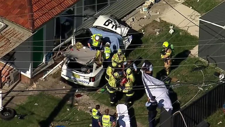 Cop car crashes into Sydney house