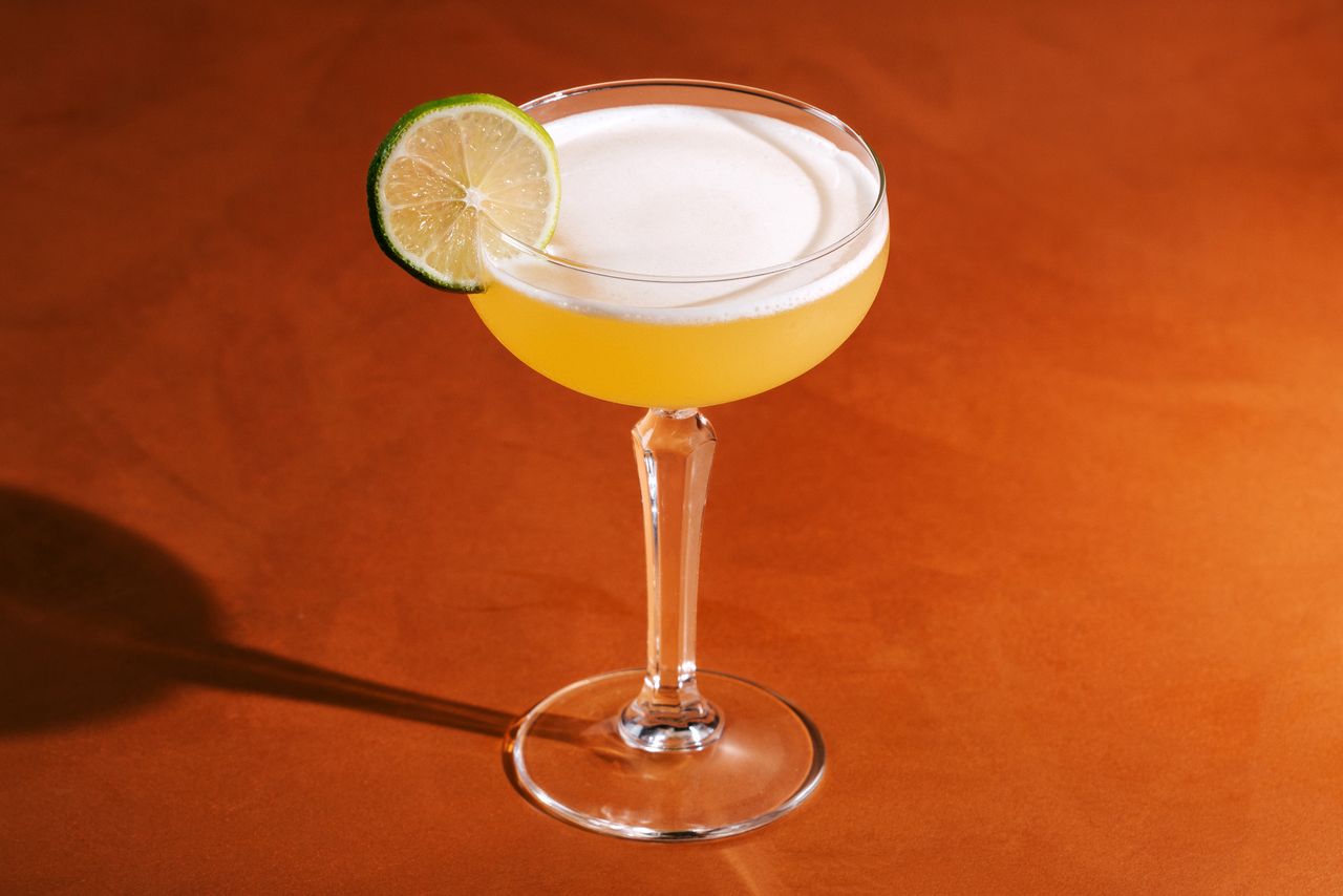 A Hotel Nacional cocktail on a rust orange backdrop.