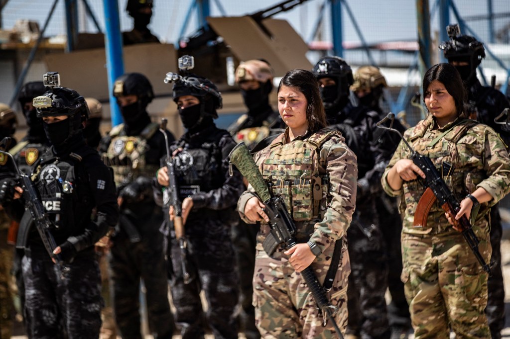 Members of the Syrian Democratic Force-affiliated Asayish security forces stand guard at the Al-Hol camp, which holds relatives of suspected ISIS fighters in the northeastern Al-Hasakah governorate, on April 18.