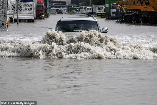 Many roads have been completely submerged in floodwater as civilians are warned to stay inside during the freak storm 