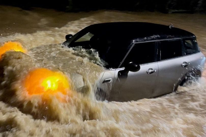 Watch as car stranded in failed attempt to pass flooded road