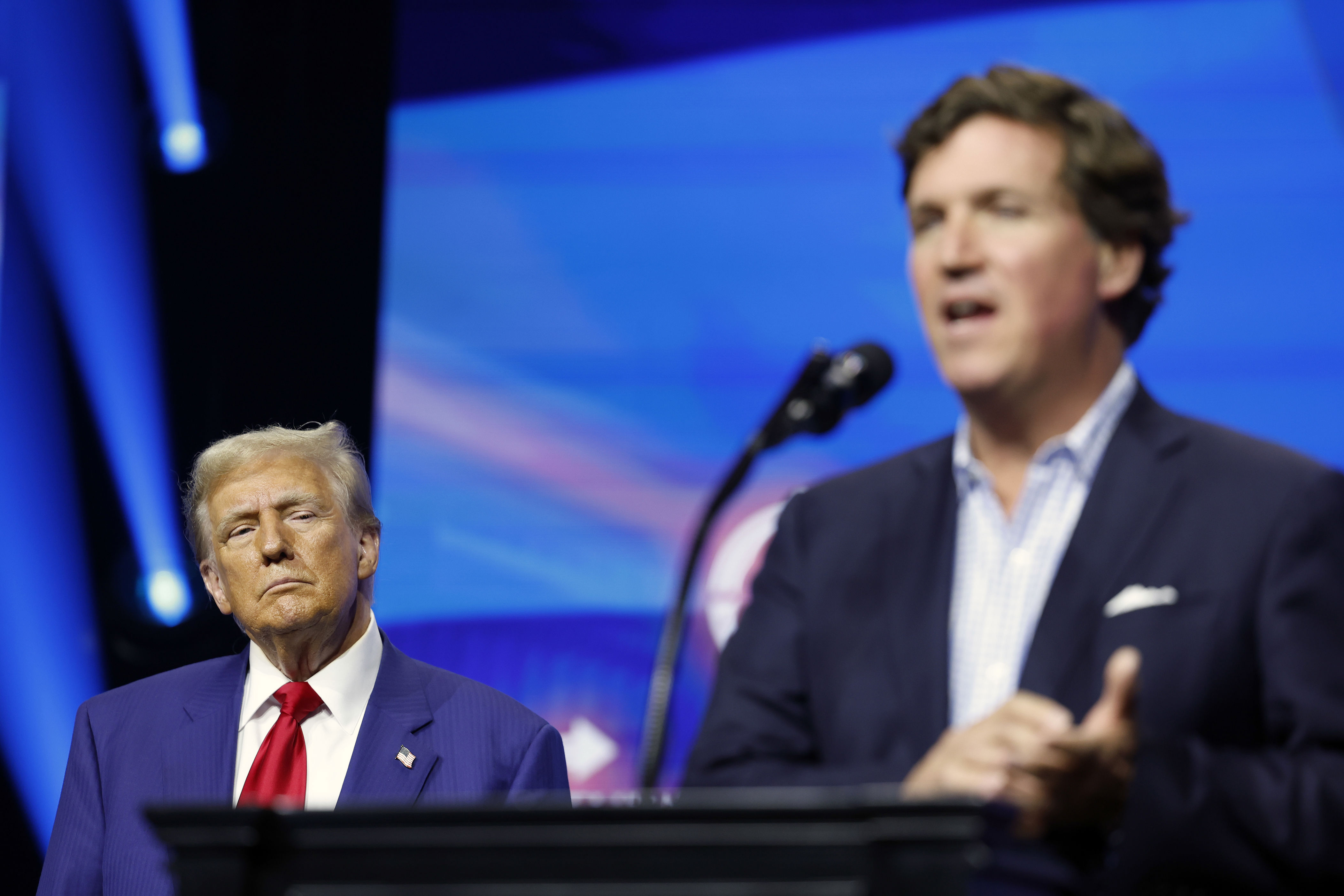 President Donald Trump watches as Carlson delivers remarks during a Turning Point Action campaign rally in 2024 in Duluth, Ga.