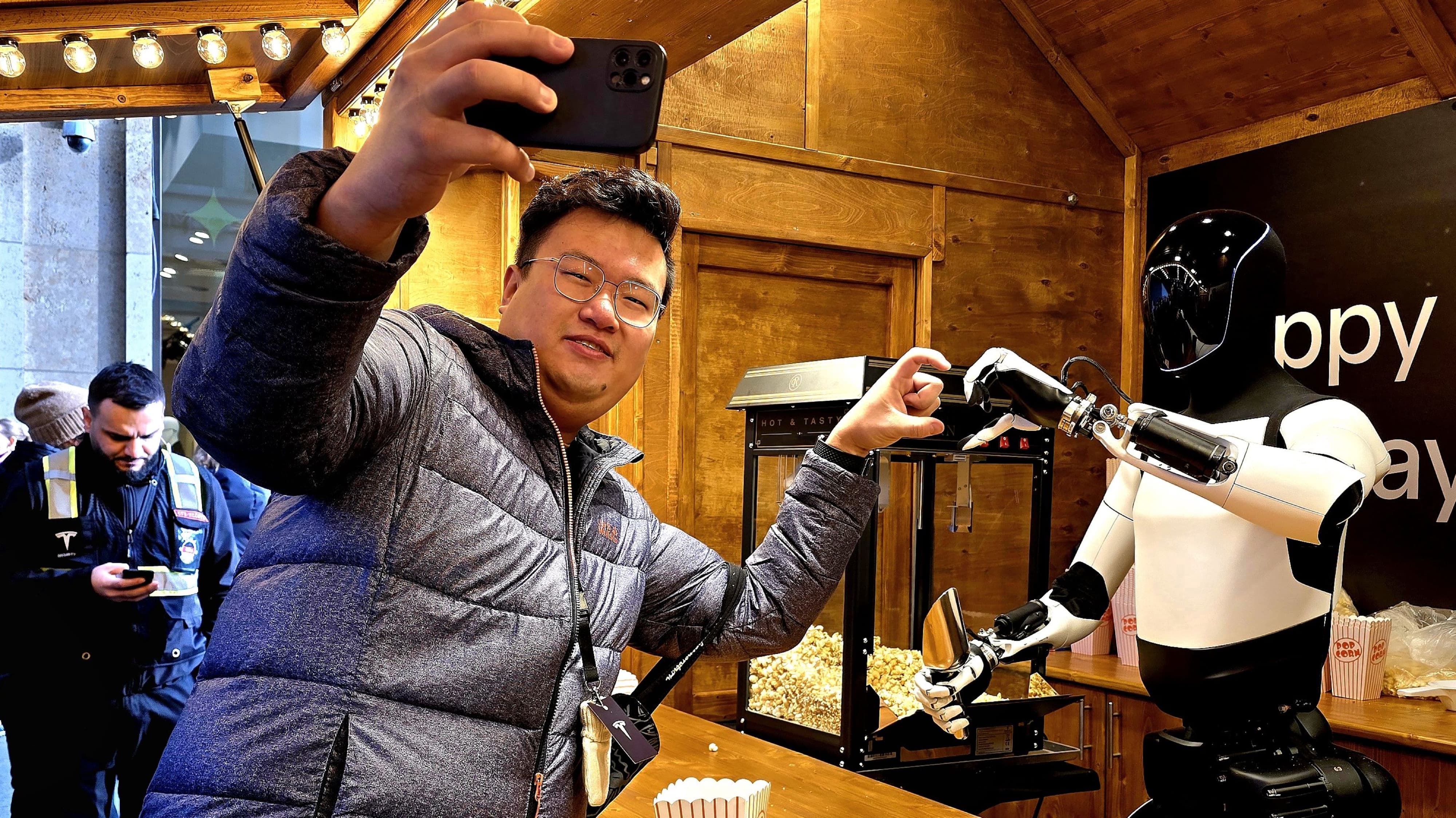 Viele der Besucher in Berlin haben keine Berührungsängste mit dem Tesla-Roboter Optimus.