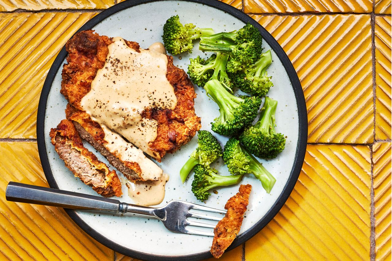 Southern Living Chicken Fried Steak with Cream Gravy on a plate to serve with broccoli