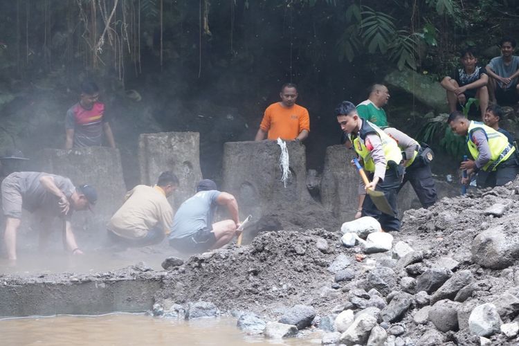 Warga bersama petugas membersihkan material banjir bandang Sungai Kali Gung di kawasan Objek Wisata (OW) Pemandian Air Panas Guci, Kabupaten Tegal, Jawa Tengah pada Sabtu (20/12/2025).