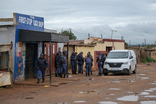 South African Police Service officers gather outside the tavern in Bekkersdal (Picture: Emmanuel Croset/ AFP via Getty Images)