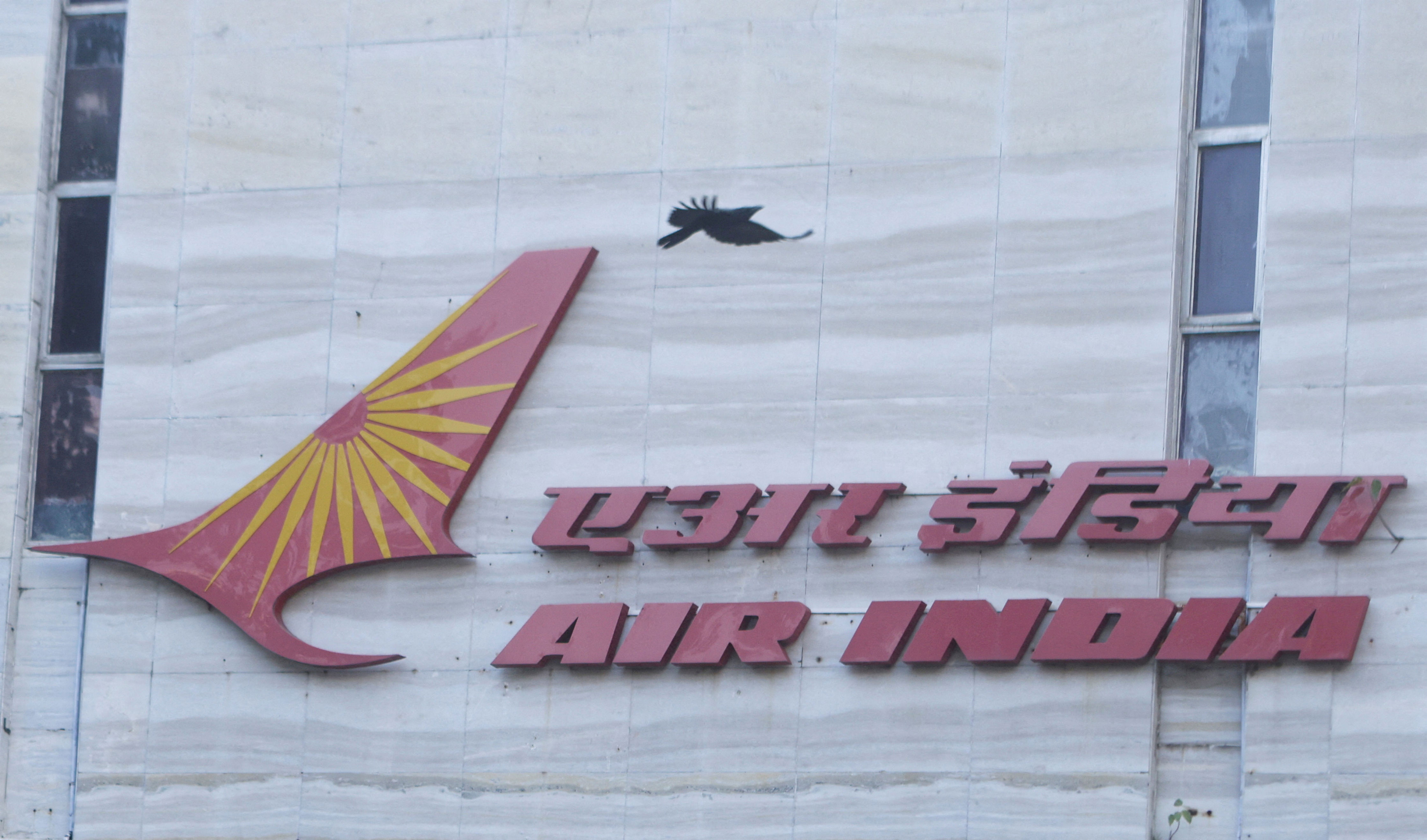 A bird flies over a logo of Air India airlines at the corporate headquarters in Mumbai (Reuters)