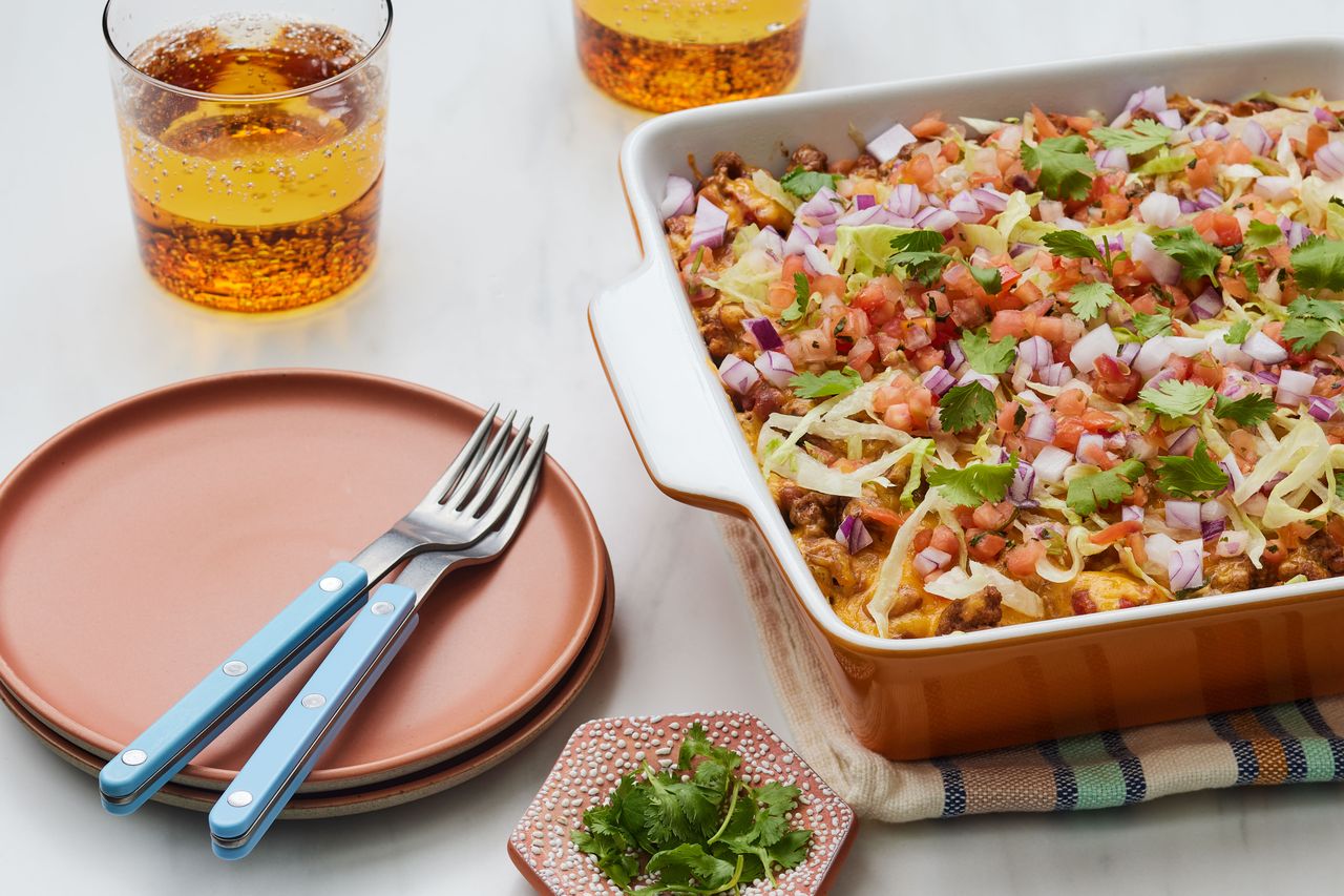 southern living easy taco casserole in a dish with plates and forks