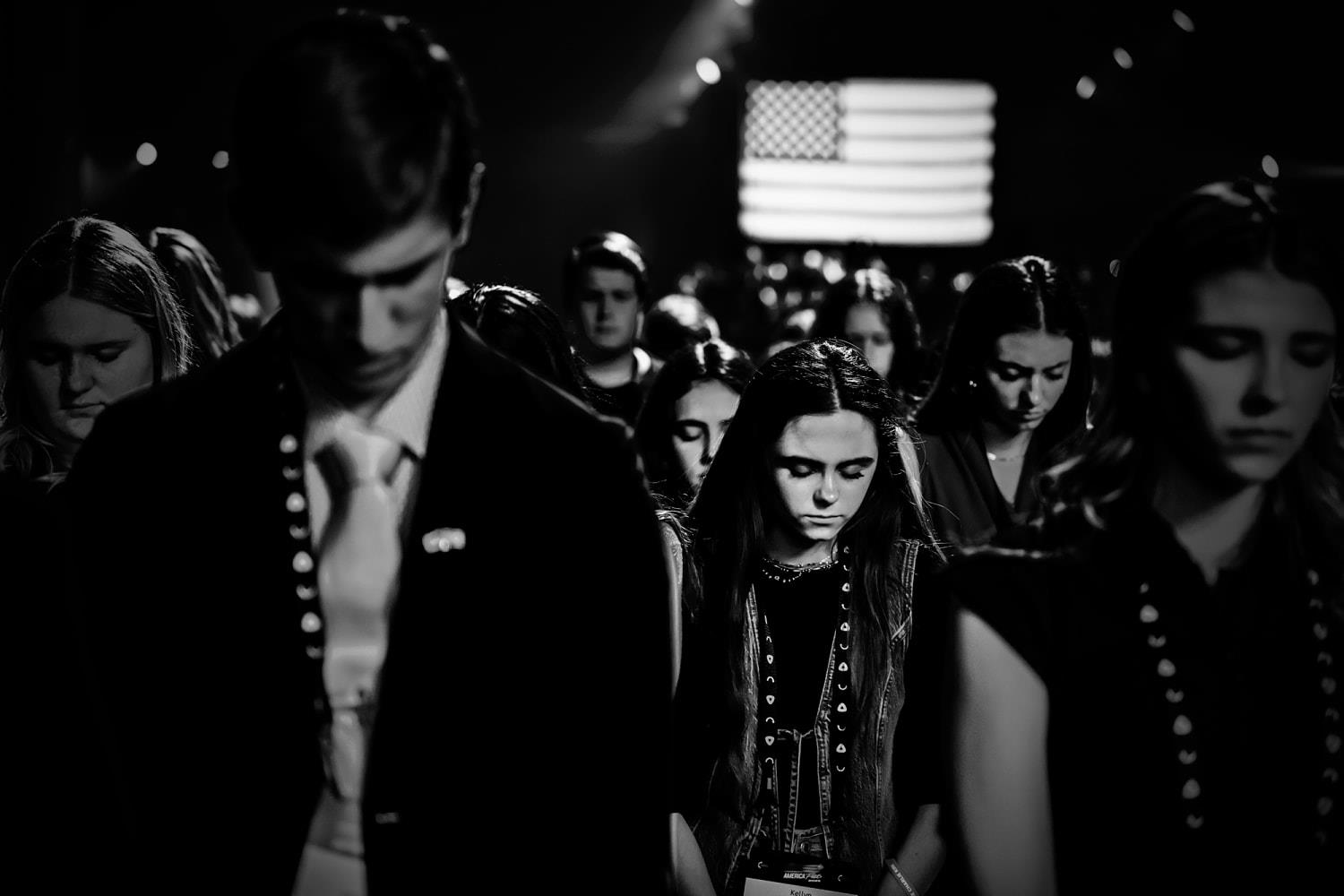 AmericaFest attendees lowering their heads in prayer. (Mark Peterson for NBC News)