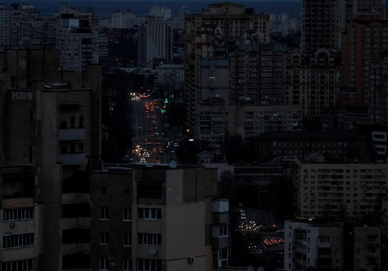 Gleb Garanich/Reuters - PHOTO: Traffic moves through Kyiv, Ukraine, during a blackout after a Russian attack on Dec. 23, 2025.