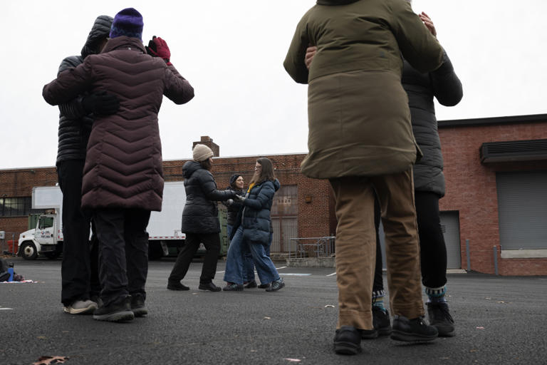 TAKOMA PARK, MD - DECEMBER 12:  Residents from the Takoma Park community take early morning salsa lessons on a parking lot where ICE agents have taken immigrants into custody. Community organizers have a handful of events planned over the next couple weeks to deter ICE agents from detaining immigrants in this particular parking lot on December 12, 2025 at in Takoma Park, Maryland. (Photo by Marvin Joseph/The Washington Post)
