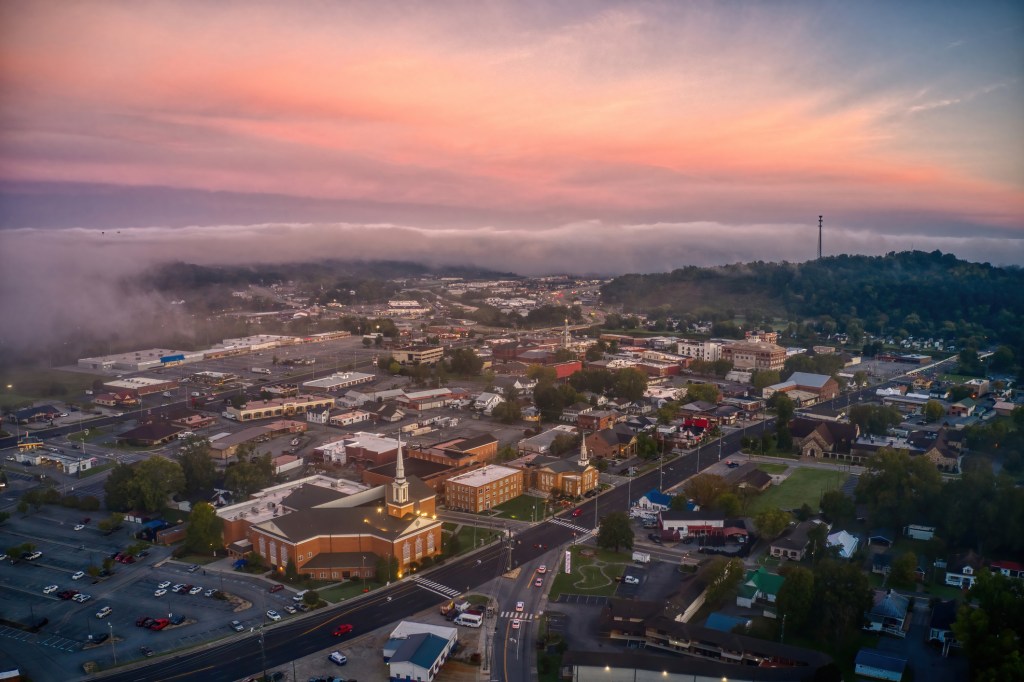 A cloudy and foggy end of the day with a view of downtown Sevierville as the sun sets into an array of brilliant purple and blue colors.
