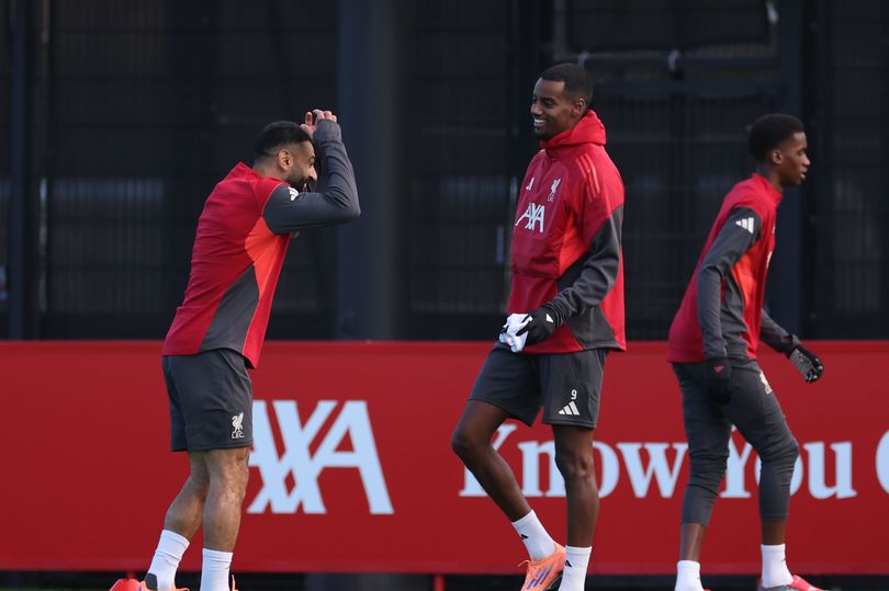 Mo Salah and Alexander Isak of Liverpool FC joke around during a training session at AXA Training Centre on December 08, 2025 in Kirkby, England.