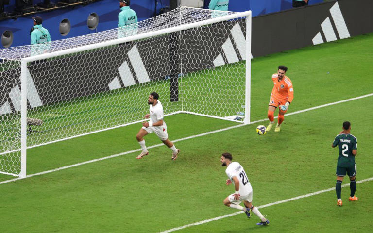 Palestine’s Oday Dabbagh celebrates scoring their first goal with Palestine’s Zeid Qunbar [Ibraheem Al Omari/Reuters]