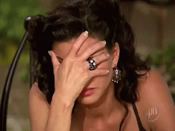 Person with long hair and earrings facepalming, displaying frustration or disbelief