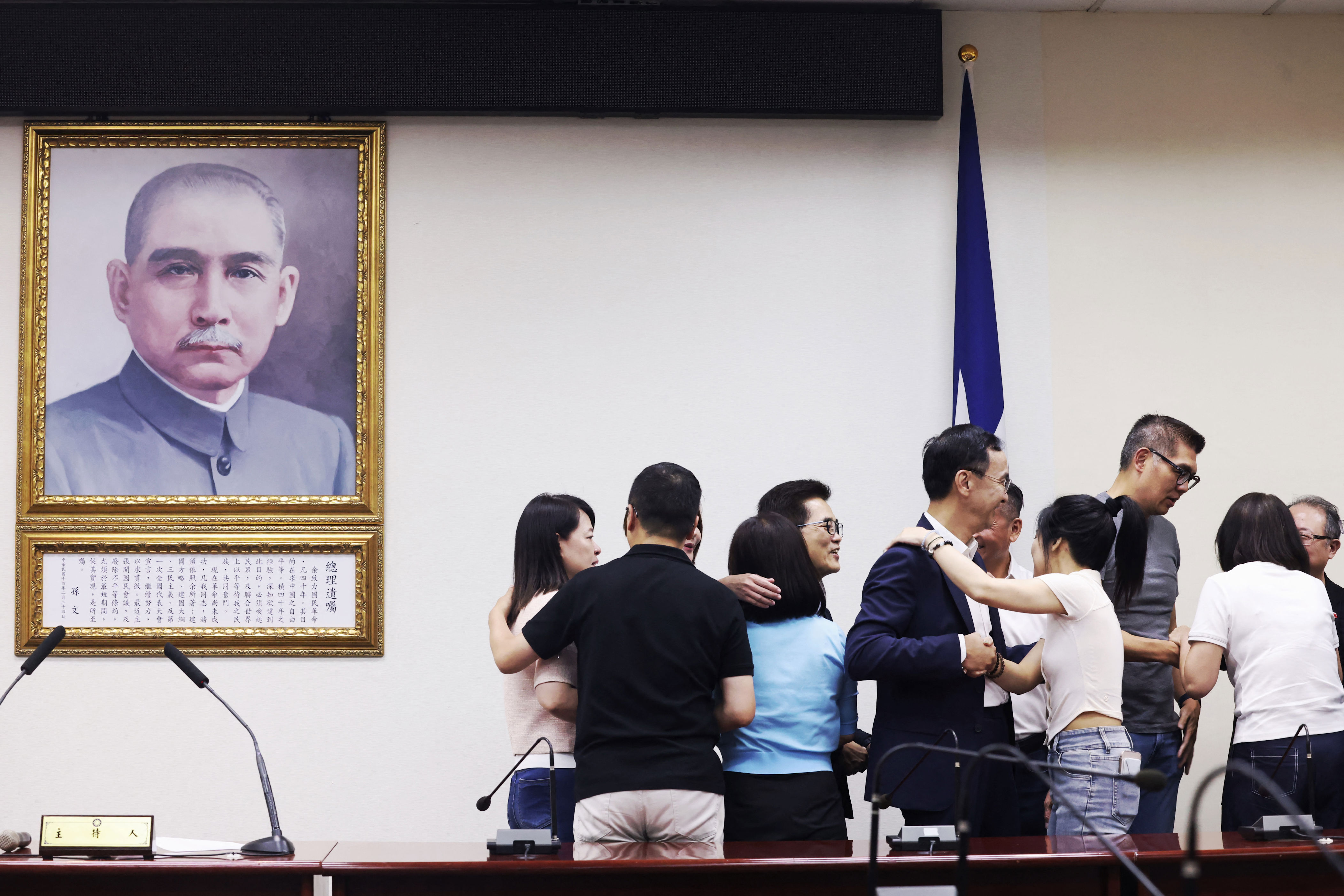 KMT lawmakers hug following recall elections in July.