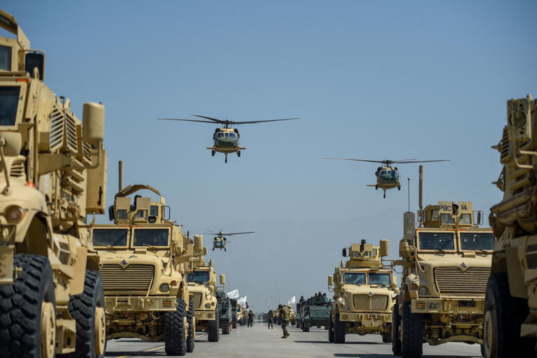 UH-60 Black Hawk helicopters fly during a celebration marking the third anniversary of the Taliban's takeover of Afghanistan, at Bagram air base outside Kabul on Aug. 14, 2024.