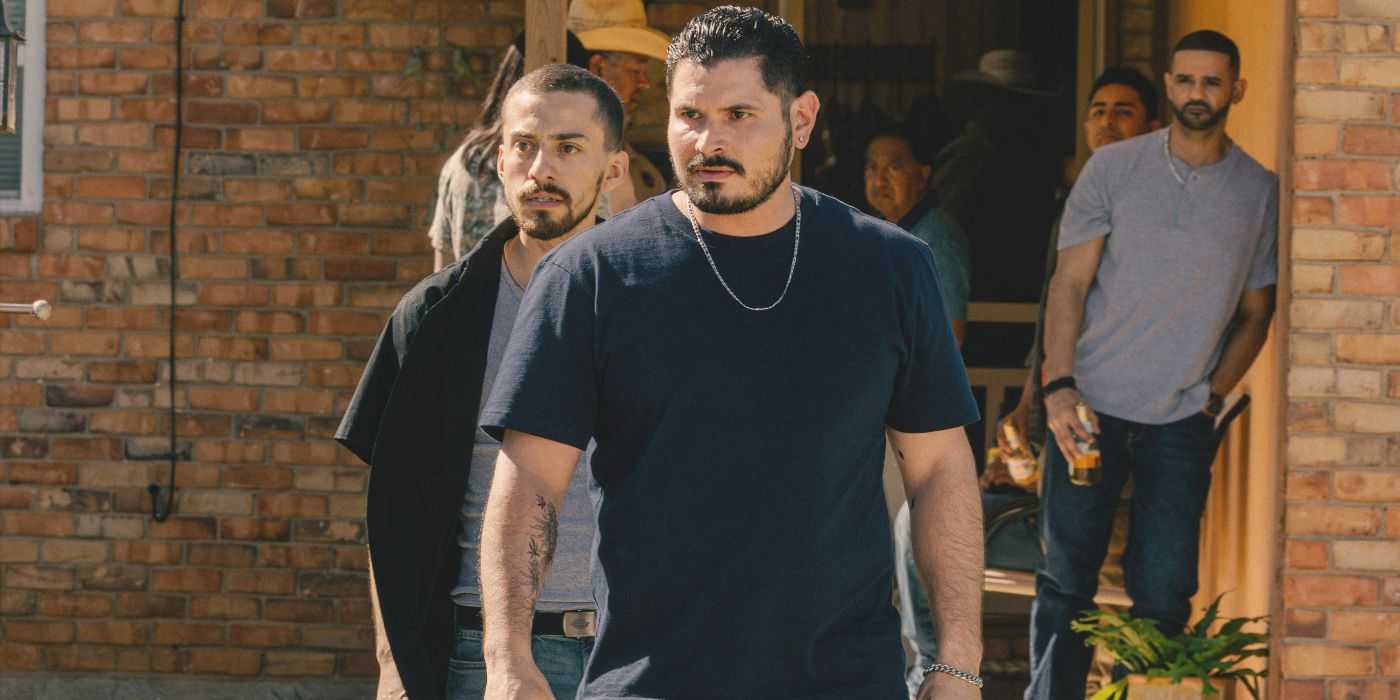 Antonio and Manuel stand menacingly outside their home with family looking on in Landman